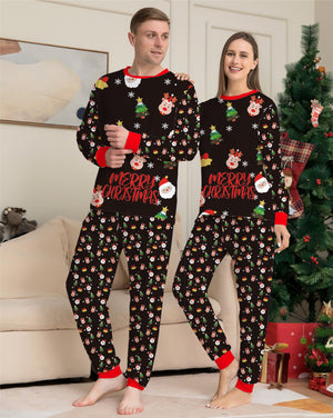 Two people wearing matching Christmas-themed pajamas in a living room with a decorated tree.