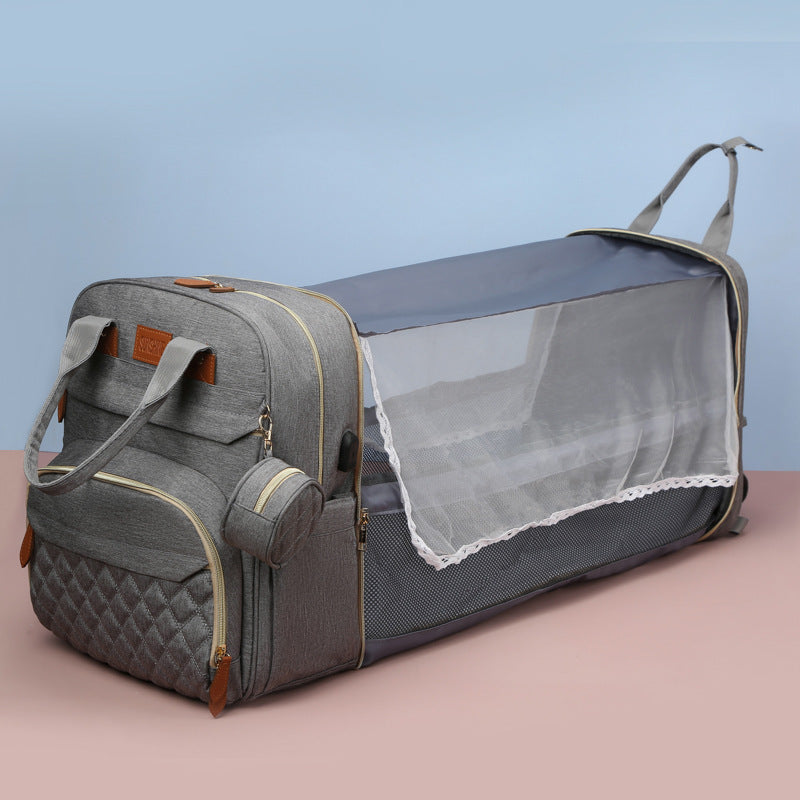 Gray pet carrier with mesh side on a pink surface and light blue background