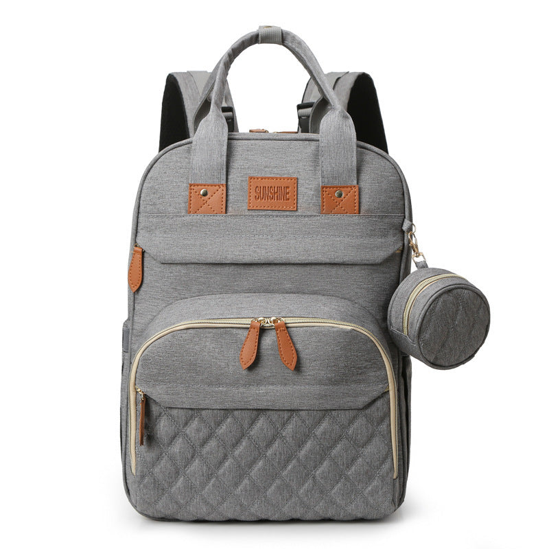 Gray backpack with quilted design and brown accents on a white background
