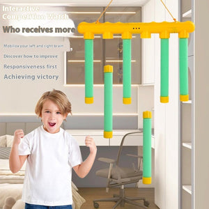 Child playing with a yellow and green interactive competition watch in a room.