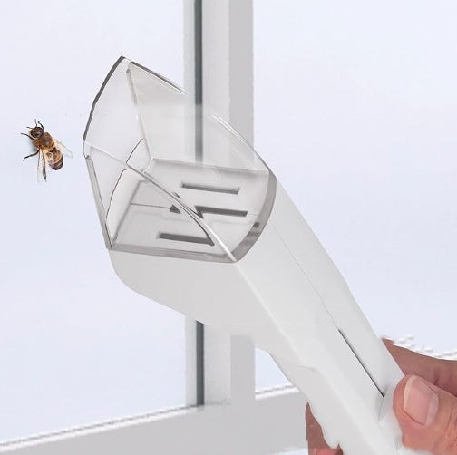 White bee smoker with a clear top held by a hand, against a light background