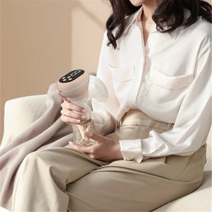 Person holding a handheld device with a beige background