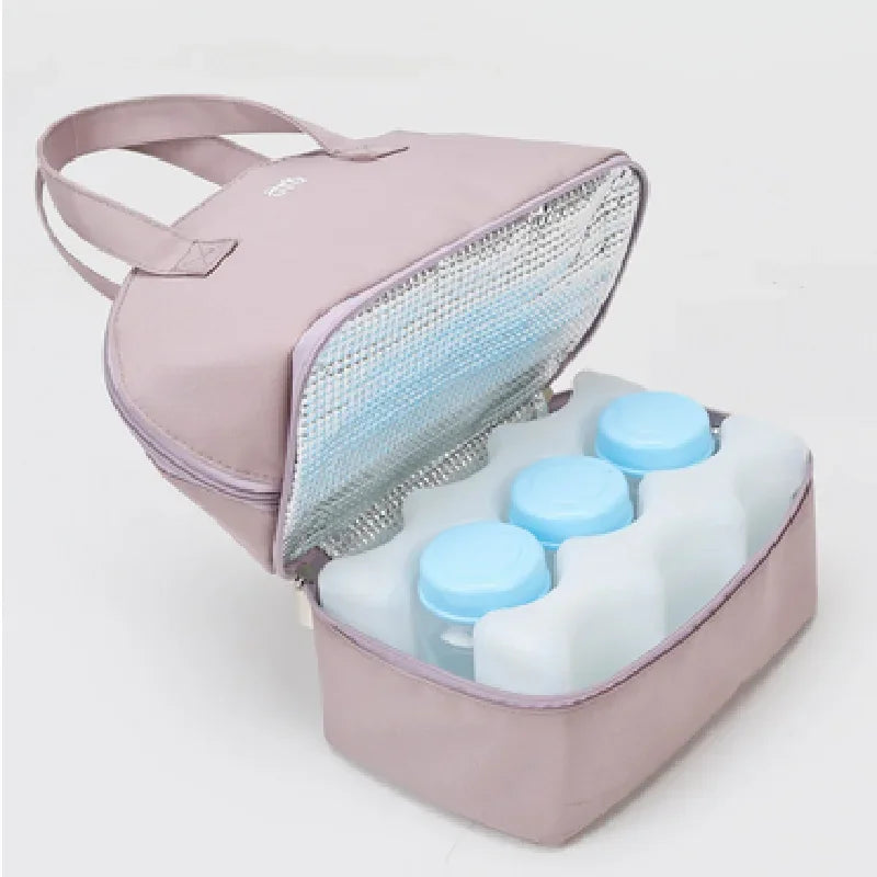 Pink insulated cooler bag with baby bottles inside on a white background