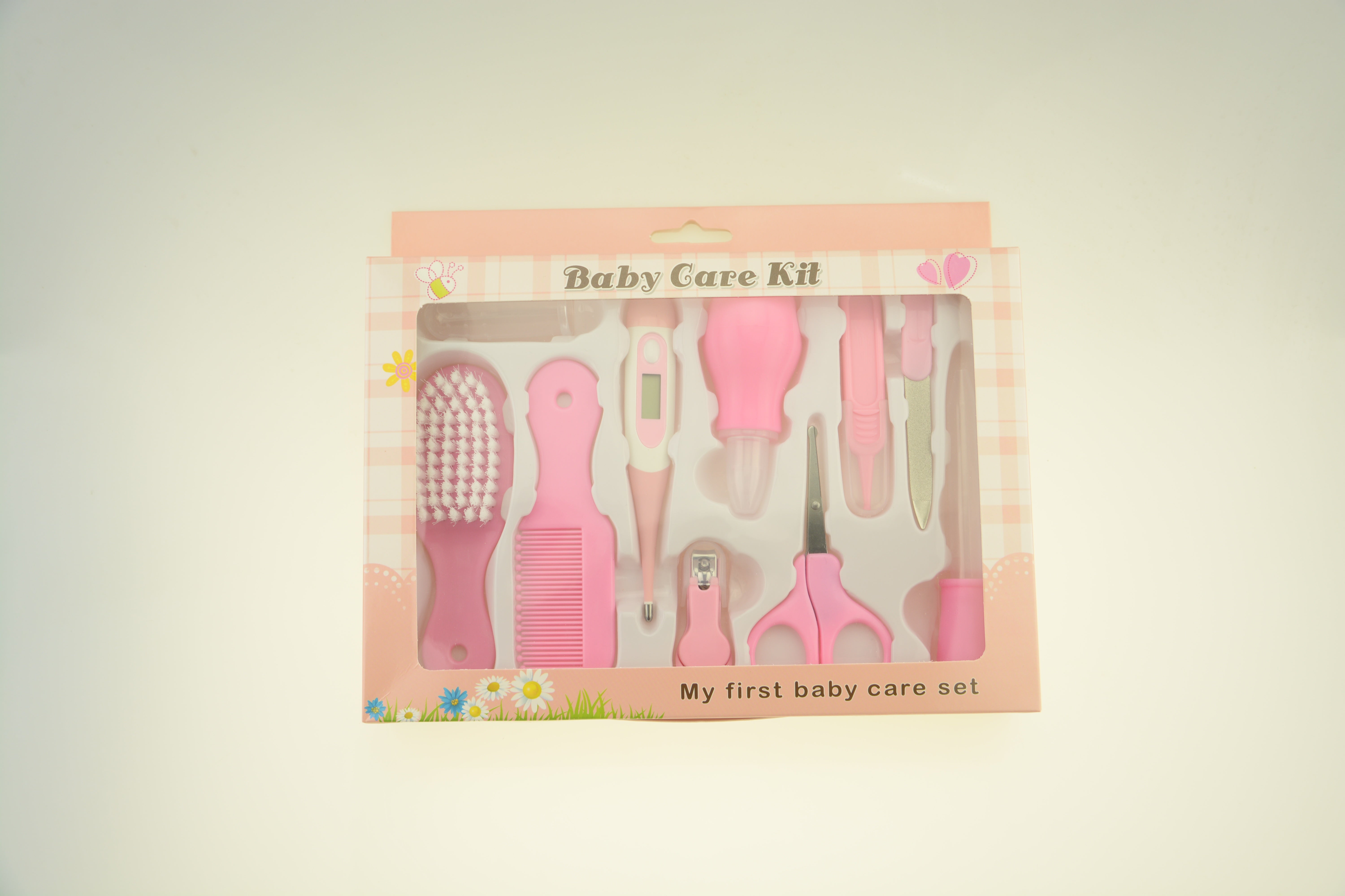 Pink baby care kit with various tools in a box on a light background