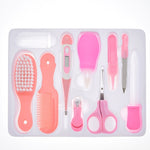 Set of pink baby grooming tools in a clear plastic case on a white background