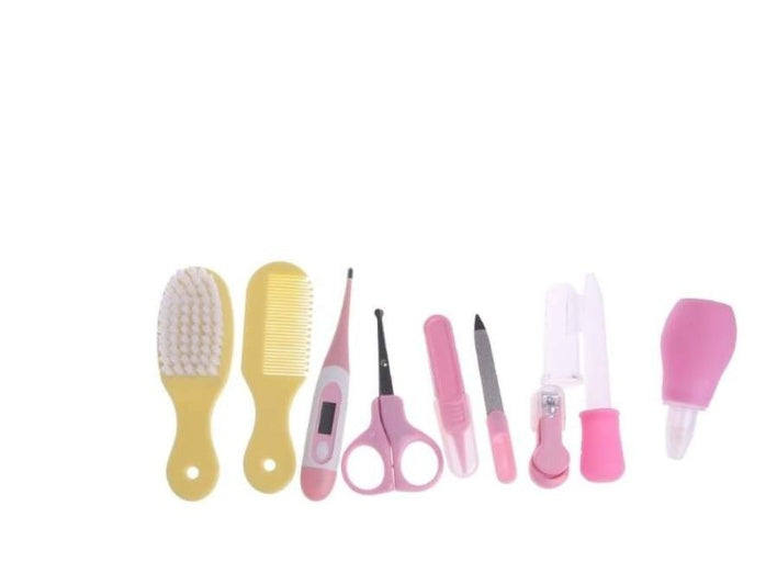 Set of baby care tools including brushes, comb, scissors, and nail care items on a white background