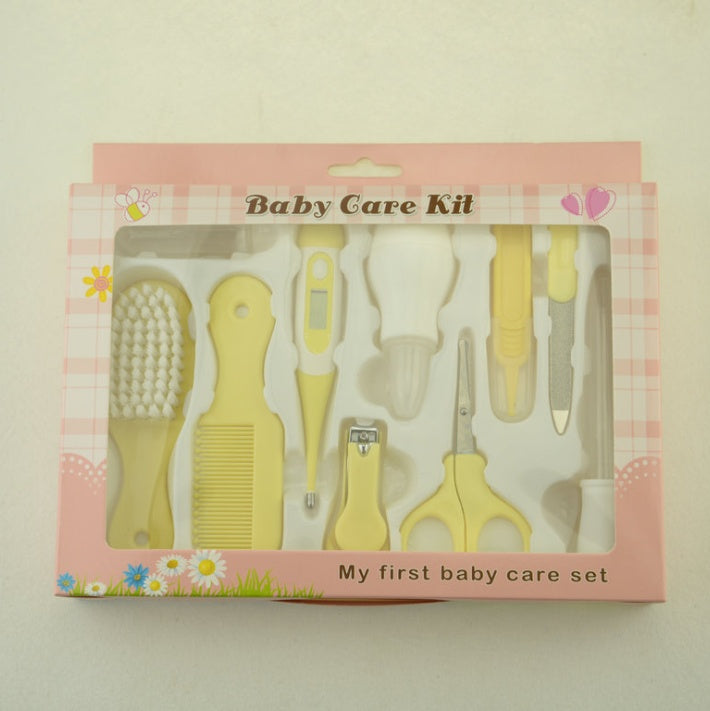 Baby care kit with yellow tools in a pink box on a light beige background