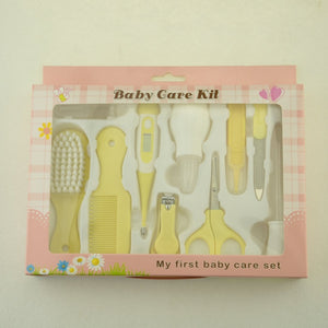 Baby care kit with yellow tools in a pink box on a light beige background