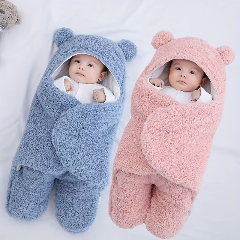 Two babies wrapped in blue and pink bear-shaped swaddles on a white background