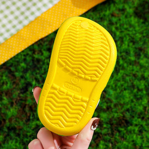 Yellow sandal sole held over a grassy background