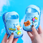 Blue children's sandals with cartoon characters and 'Pilot' branding on a blue background
