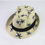 Beige straw hat with palm tree pattern and black band on a white background