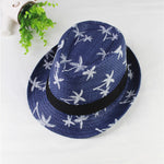 Blue straw hat with white patterns on a white surface