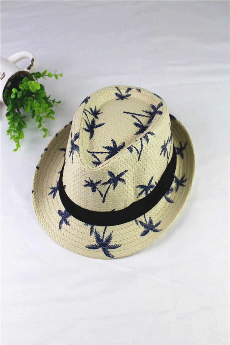 Beige straw hat with blue floral patterns and a black band on a white background