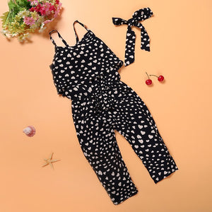 Black and white patterned jumpsuit with a belt on an orange background