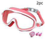 Pink and white swim mask with two pink earplugs on a white background