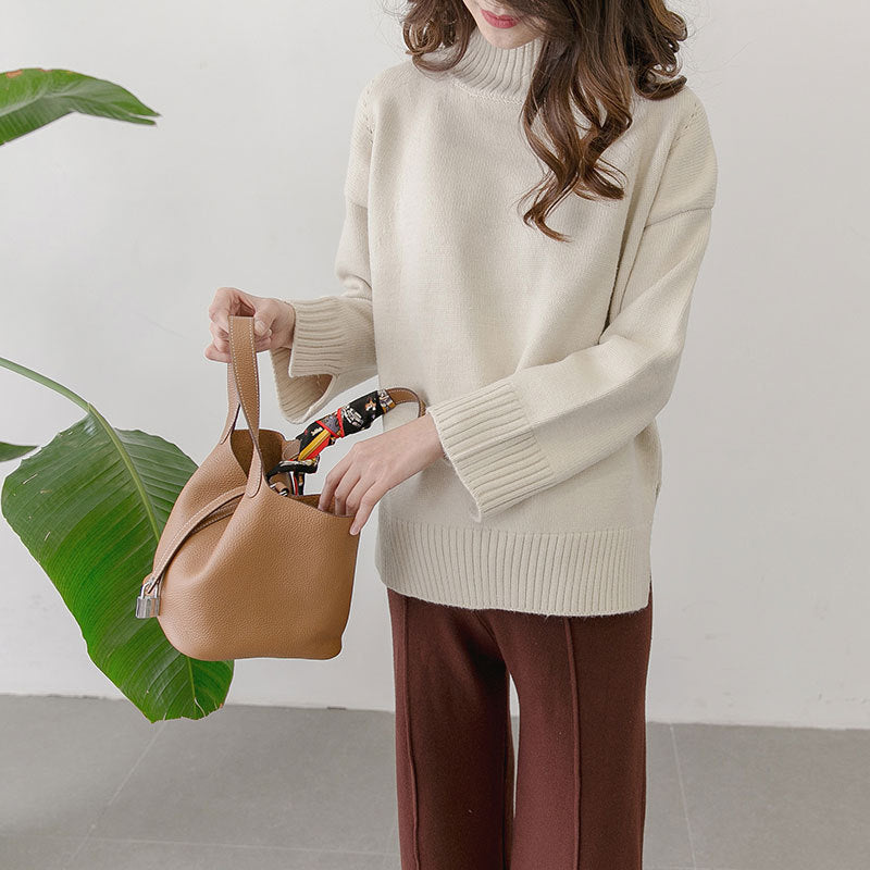 Person holding a brown handbag with a white background