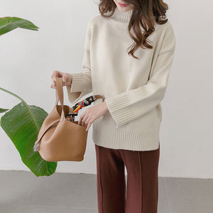 Person holding a brown handbag with a white background