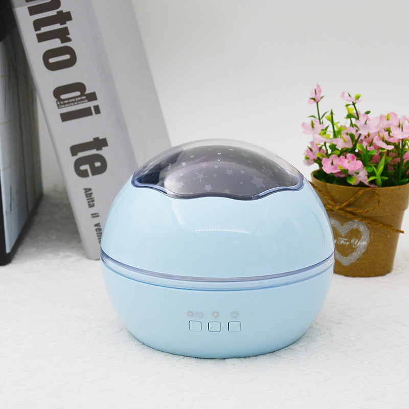 Blue spherical humidifier on a white surface with a plant and book in the background