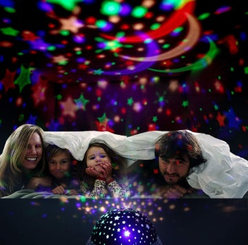 Family under a blanket with colorful star projector on ceiling
