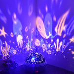 Underwater-themed night light projector with colorful projections on a dark background