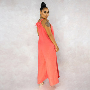 Woman wearing a coral dress against a plain background