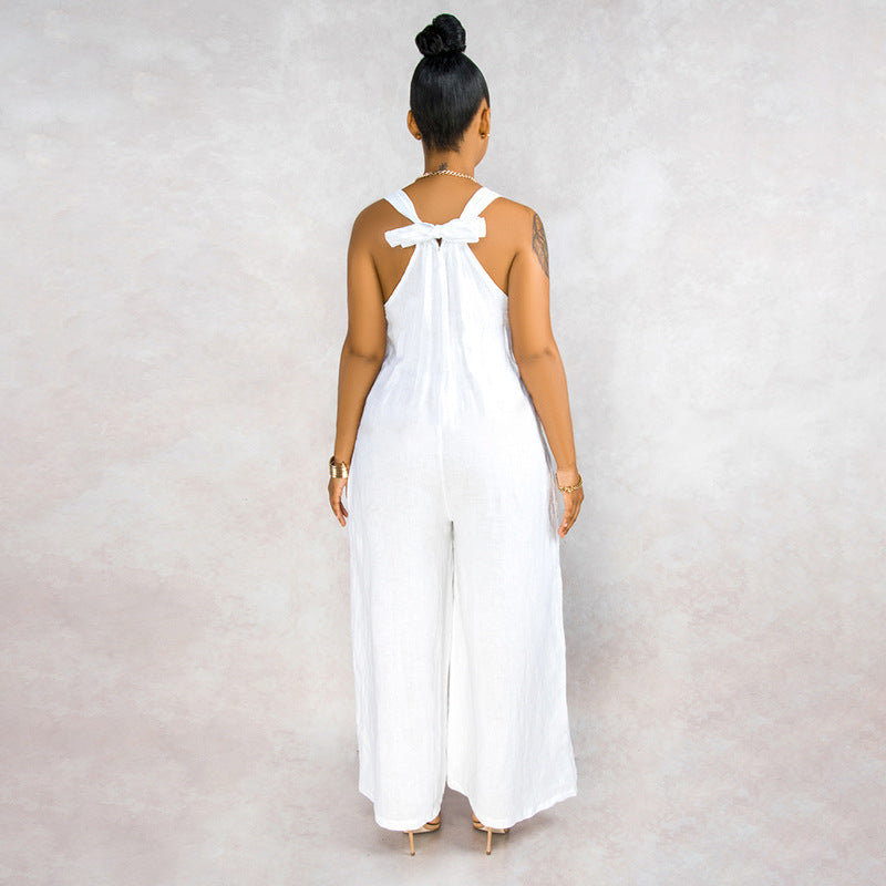 Woman wearing a white jumpsuit with a bow detail on the back against a plain background