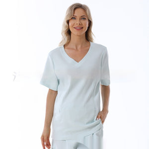 Woman wearing a light blue top and pants on a white background
