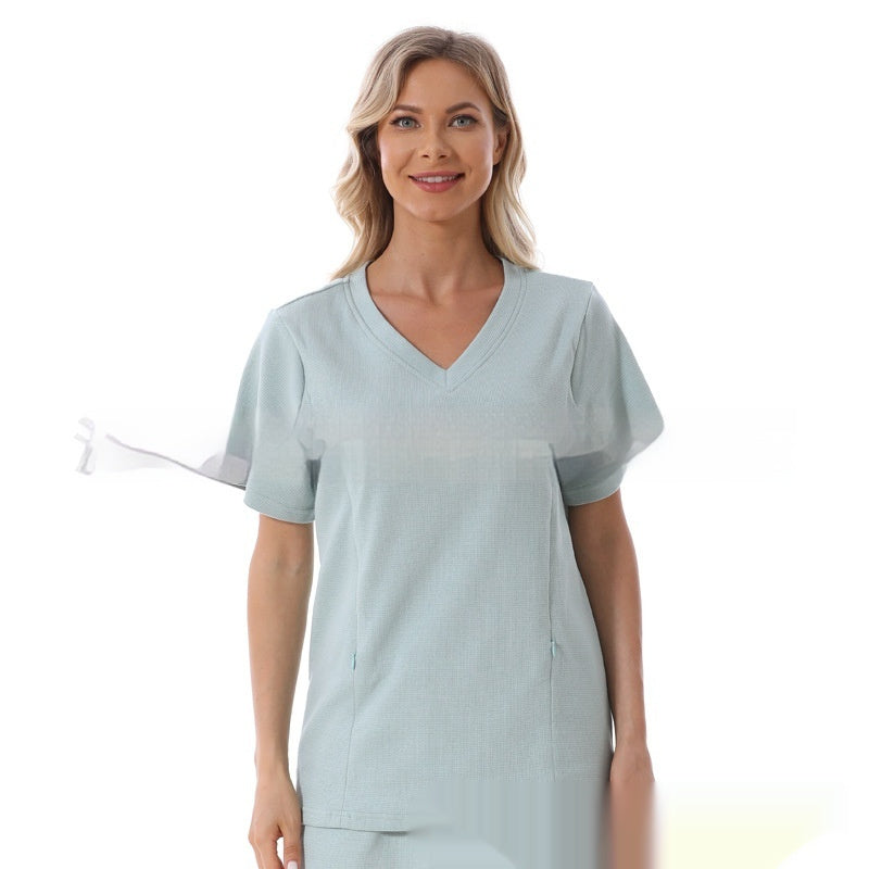 Woman wearing a light blue scrub top on a white background