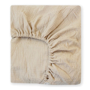 Beige fitted sheet on a mattress against a white background