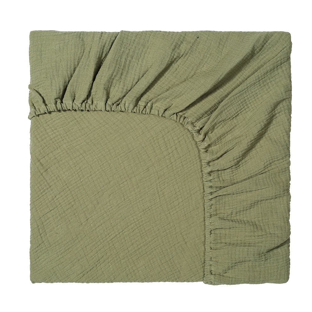 Green fabric with a textured pattern on a white background