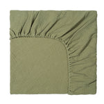 Green fabric with a textured pattern on a white background