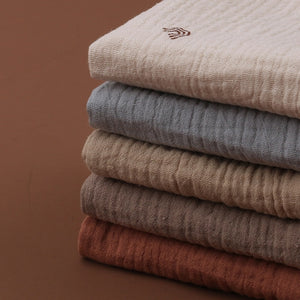Stack of folded sweaters in various colors on a brown background