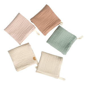 Five ribbed knit pot holders in various colors on a white background