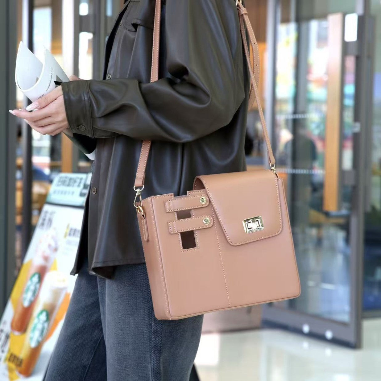 Person holding a brown handbag in an indoor setting