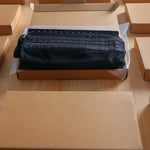 Black fabric in a cardboard box on a wooden surface