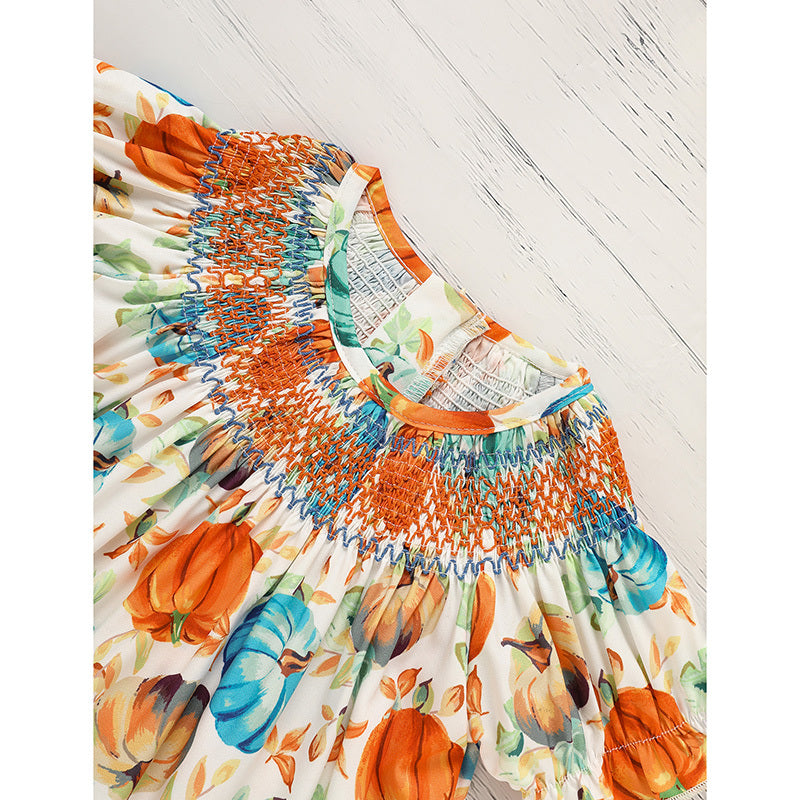 Colorful dress with pumpkin pattern on a white wooden floor