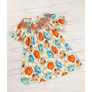 Dress with pumpkin pattern on a light wooden surface