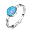 Silver ring with a blue opal stone on a white background