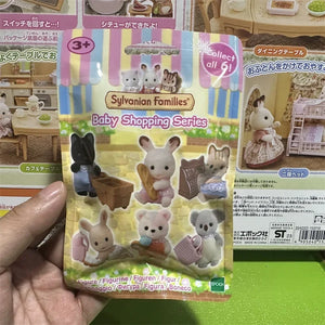 Sylvanian Families Baby Shopping Series packaging held by a hand on a green surface.