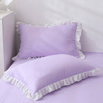 Purple bedding set with ruffled edges on a white background