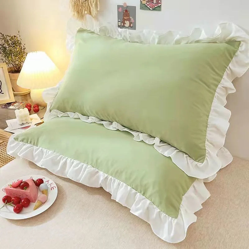 Olive pillows with ruffled edges on a bed in a bedroom setting.
