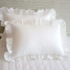 White ruffled pillows on a neutral background