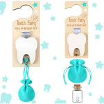 Two packages of tooth fairy picks with a turquoise pouch and glass bottle on a star-patterned background.