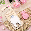 Tooth Fairy pick-up and drop-off kit with a tooth-shaped container on a decorative surface with flowers and pearls.
