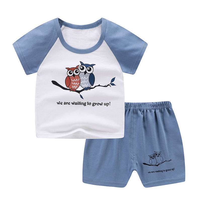 Children's outfit with a white shirt and blue shorts featuring owl graphics and text on a white background.
