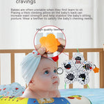 Baby with a teething ring and educational toys on a crib