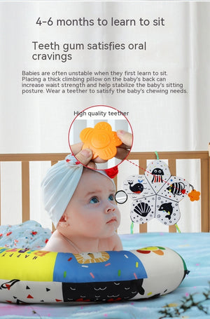 Baby with a teething ring and educational toys on a crib