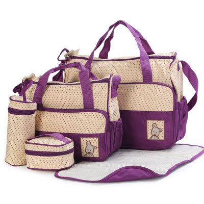 Set of purple and beige diaper bags with accessories on a white background