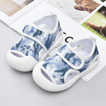 Pair of blue and white children's sandals on a light gray surface.
